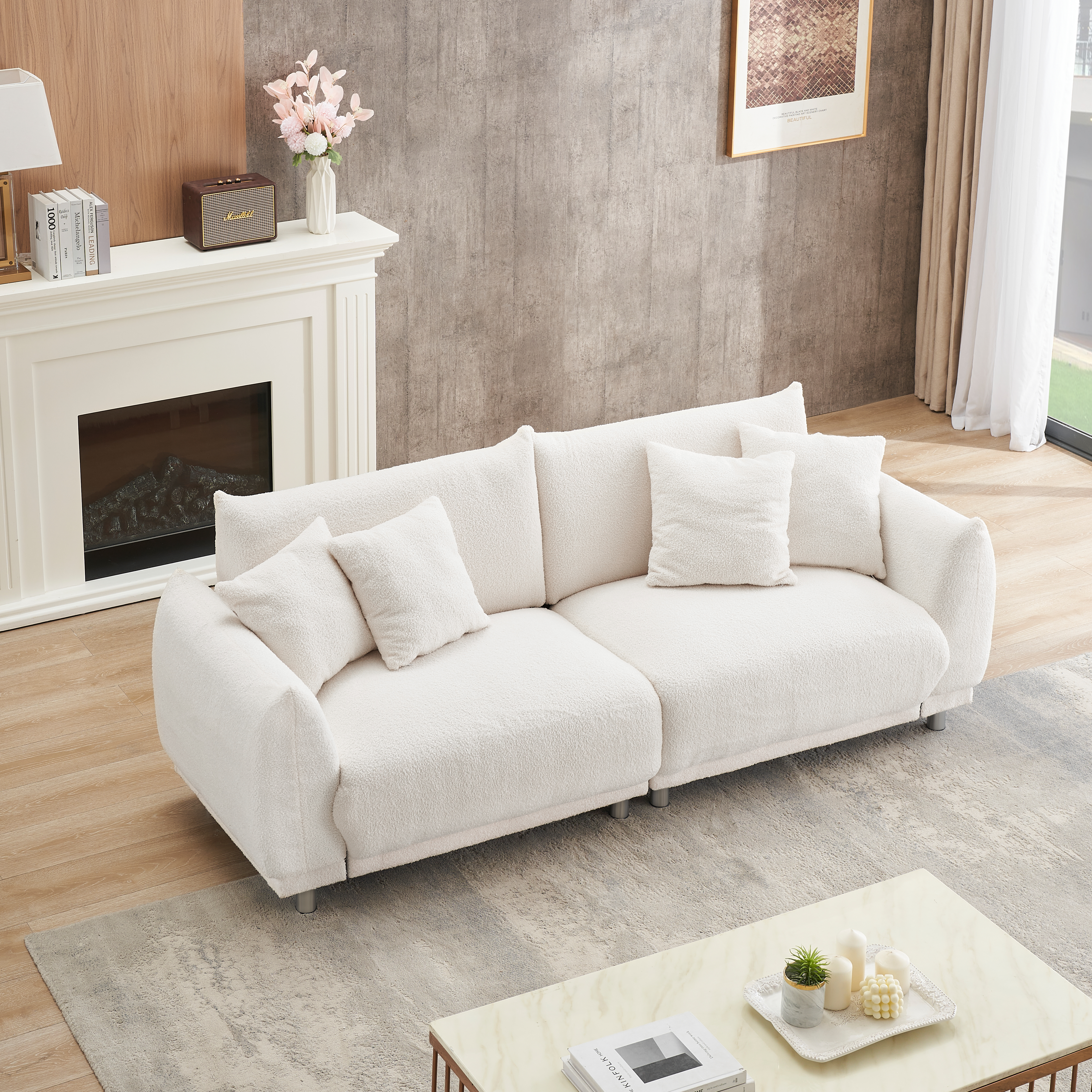 The 86.6 inch teddy wool beige sofa with four throw pillows and hardware feet can sit comfortably in an apartment bedroom without taking up space